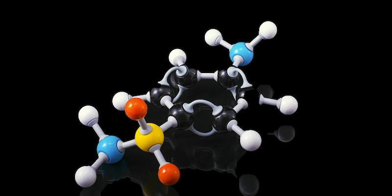 A molecule model with reflection on a dark surrounding. Sulfanilamide if someone is really interested !!Sulfanilamide was a medicine used to treat streptococcal infections. One  version of the drug, in liquid form, was introduced in the market after  having being tested only for flavor, appearance and fragrance but not for toxicity. It caused the deaths of more than 100 people back in 1937. As we are all awaiting the cure for COVID19 let his be a reminder of what untested, unsafe and "rushed to market" drugs can do to people.. Photo by Terry Vlisidis, Unsplash.