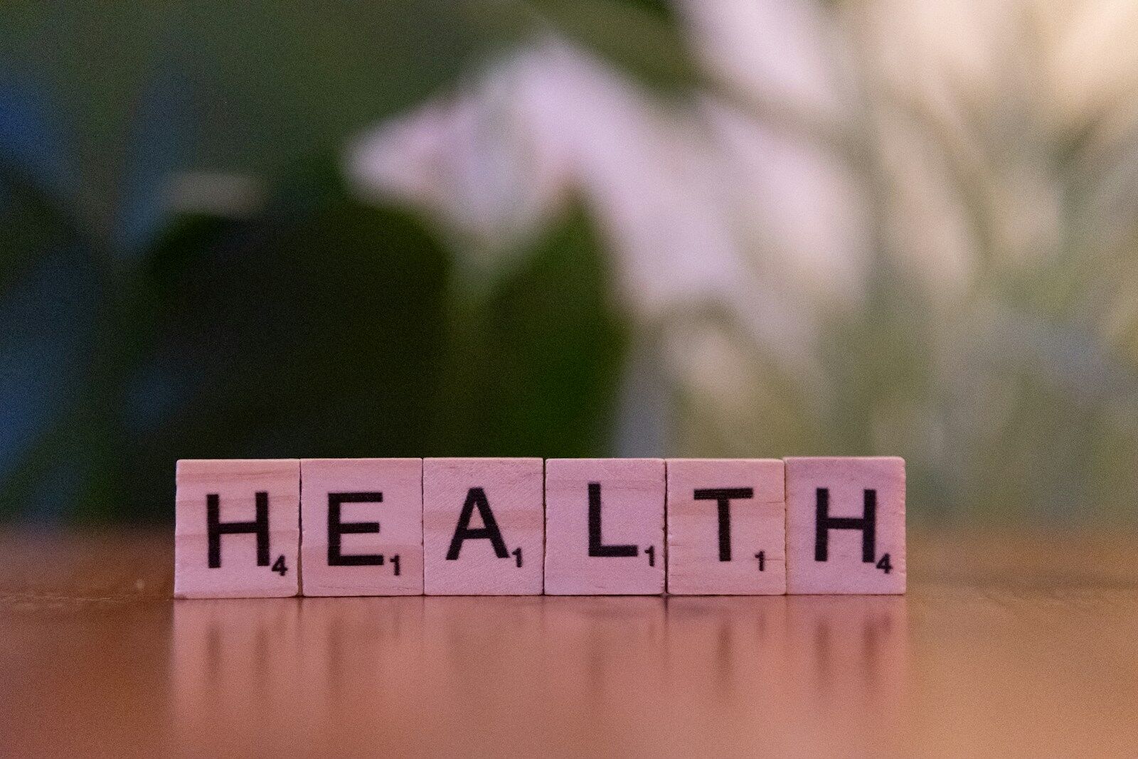 A wooden block spelling the word health on a table. Photo by Markus Winkler, Unsplash.