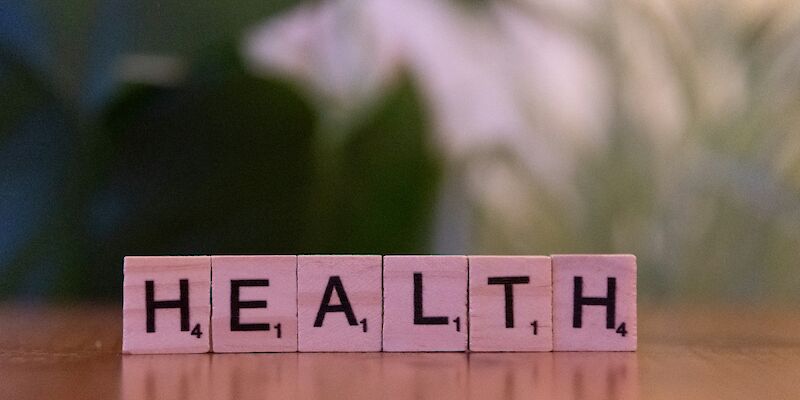 A wooden block spelling the word health on a table. Photo by Markus Winkler, Unsplash.